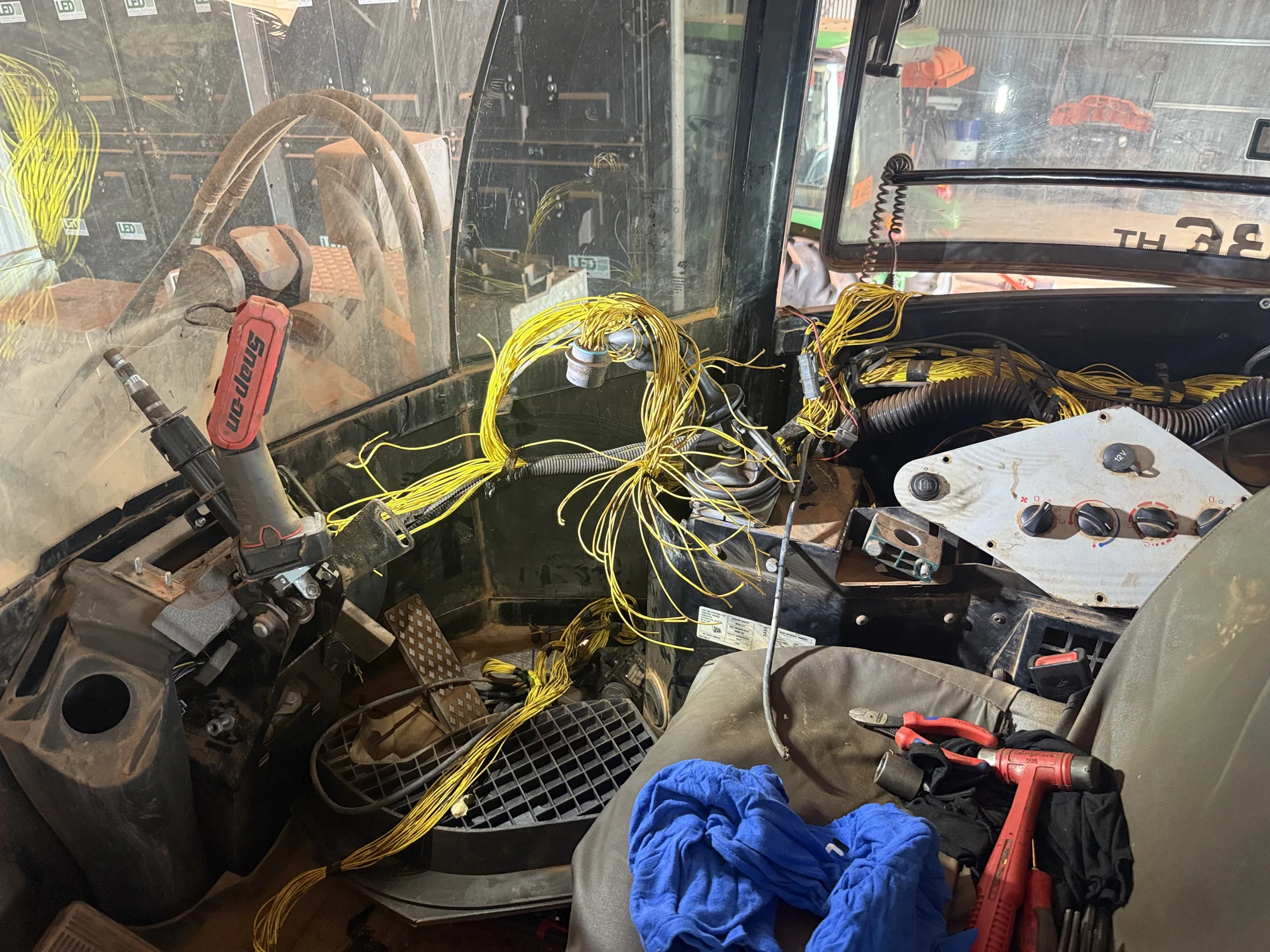 Machine cab with the dash stripped back and wiring loom exposed for electrical repairs