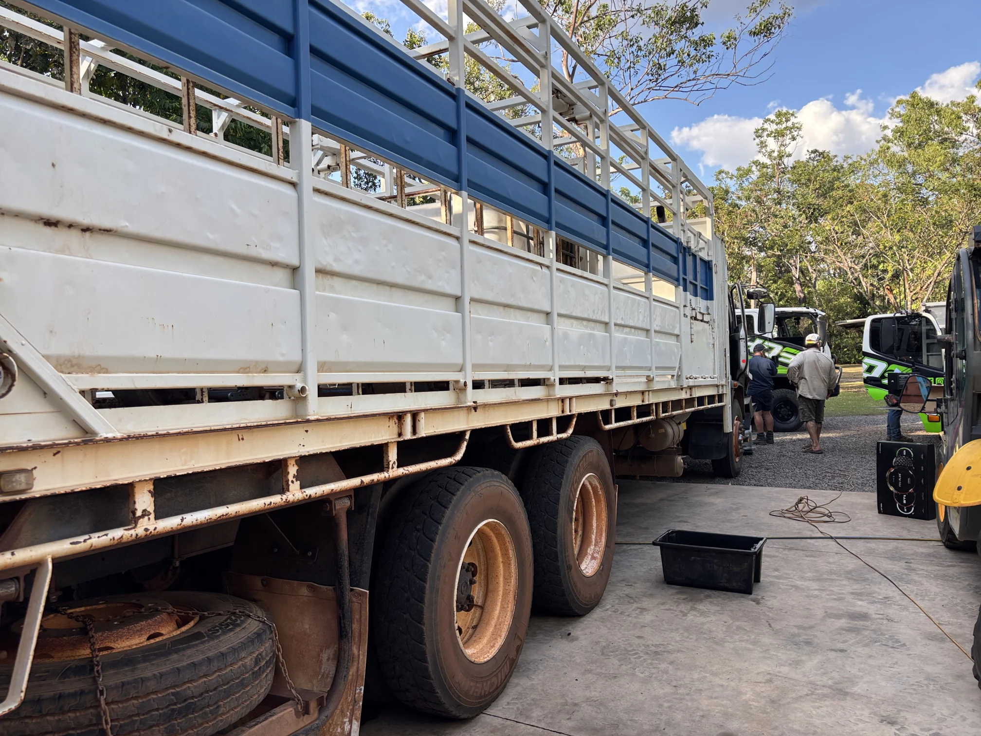 Isuzu stock truck on site for repairs, with NHDS service trucks and crew in the background